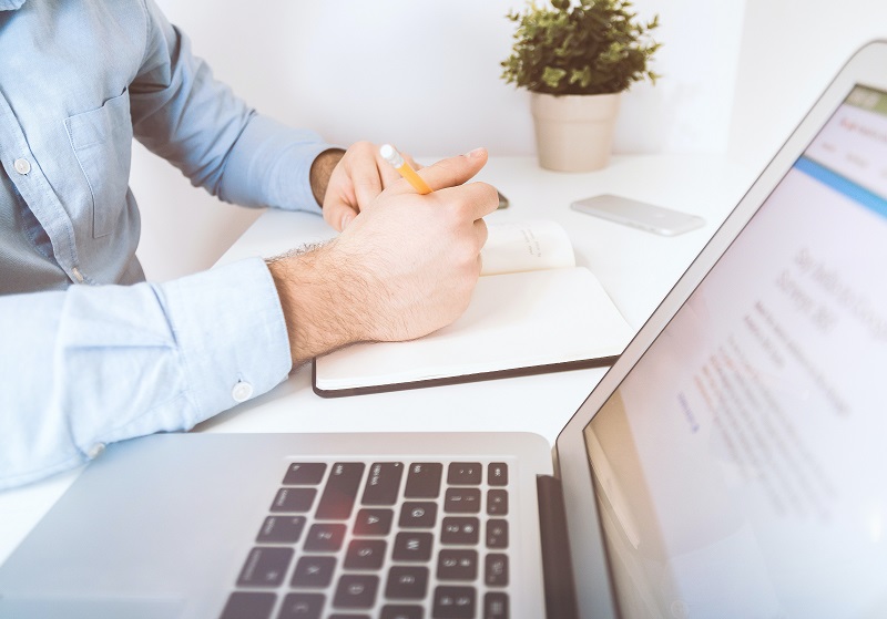 Man antecknar vid laptop