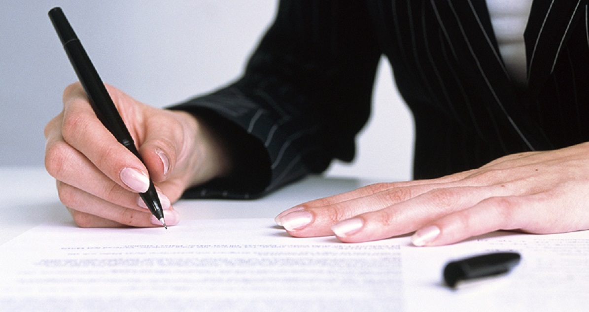 Kvinna skriver på avtal